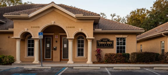 View of office from parking lot showing address and business sign